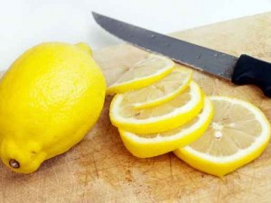Lemon with slices on cutting board