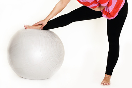 Mädchen dehnt sich auf einem Ball