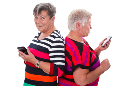Zwei Seniorinnen kommunizieren per Handy