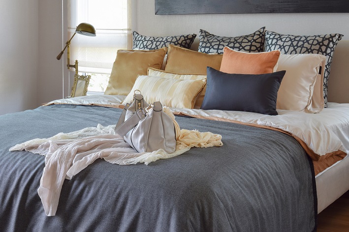 modern bedroom interior with vintage handbag on the bed