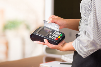 Close up of credit card machine, a woman hand swaping a gray card