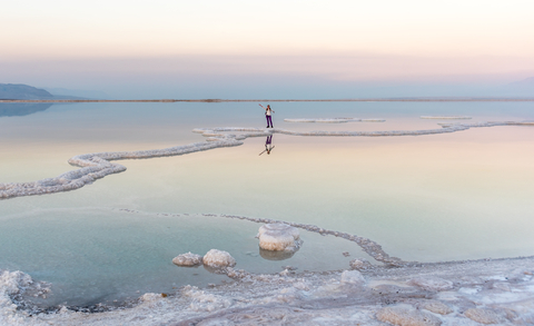 Women standing in the Dead Sea at Sunset
